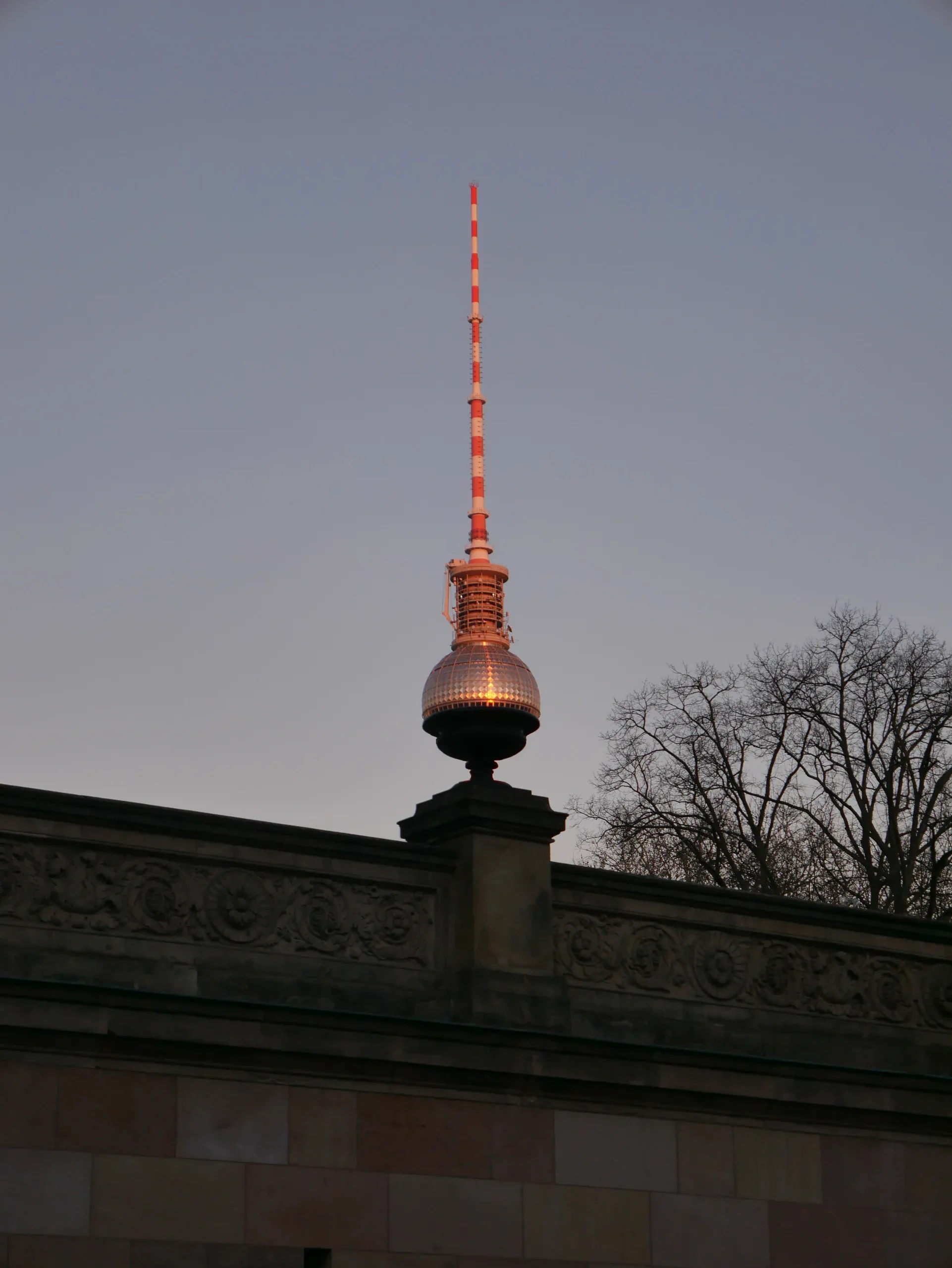 Tour de télévision de Berlin (Fernsehturm) au crépuscule vue depuis le bas d'un bâtiment