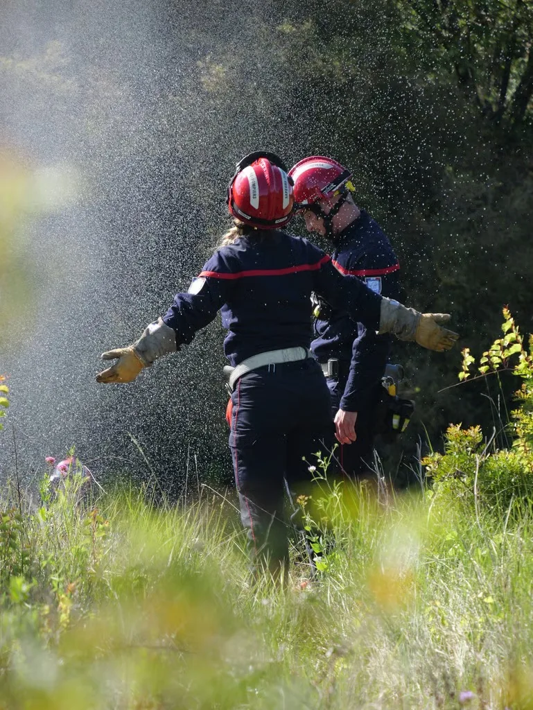 Sapeurs-pompiers lors d'un exercice avec lance à incendie